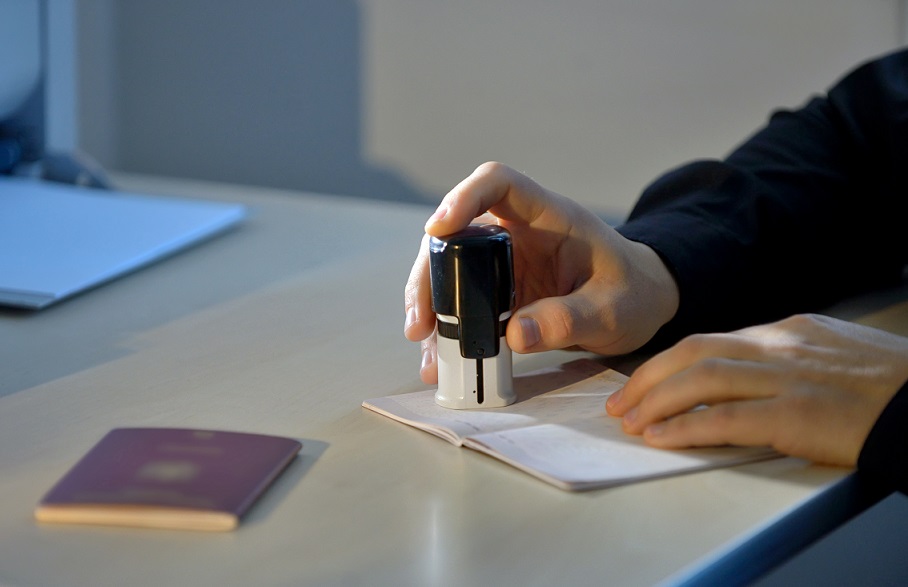 Immigration Officer Stamping a Travelling Passport