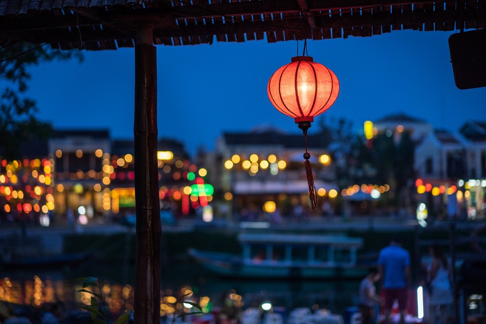 Night view of a busy street by the river of Hoi An