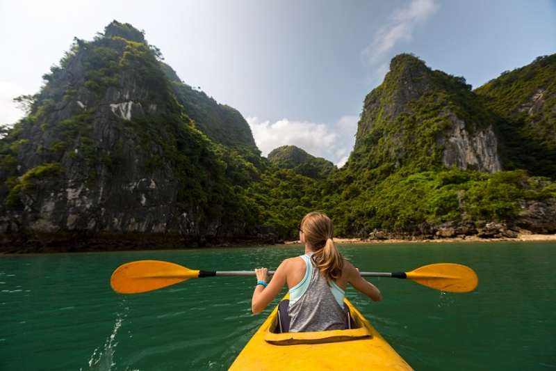 A tourist exploring Ha Long Bay (UNESCO World Heritage Site) by kayak.