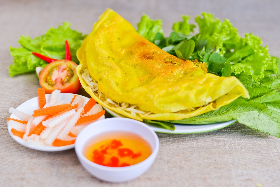 Banh xeo - Vietnamese rice pancake with fish sauce, tomato and fermented carrot