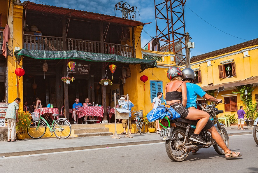 A couple travelling to Hoian old town by motorbike