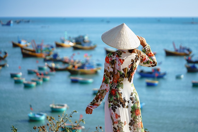 A tourist in Vietnamese traditional costume at the fishing village in Mui Ne, Phan Thiet
