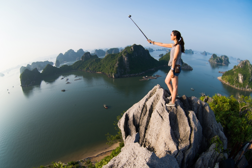 A tourist taking selfie on top of mountain to enjoy the great view of Halong Bay