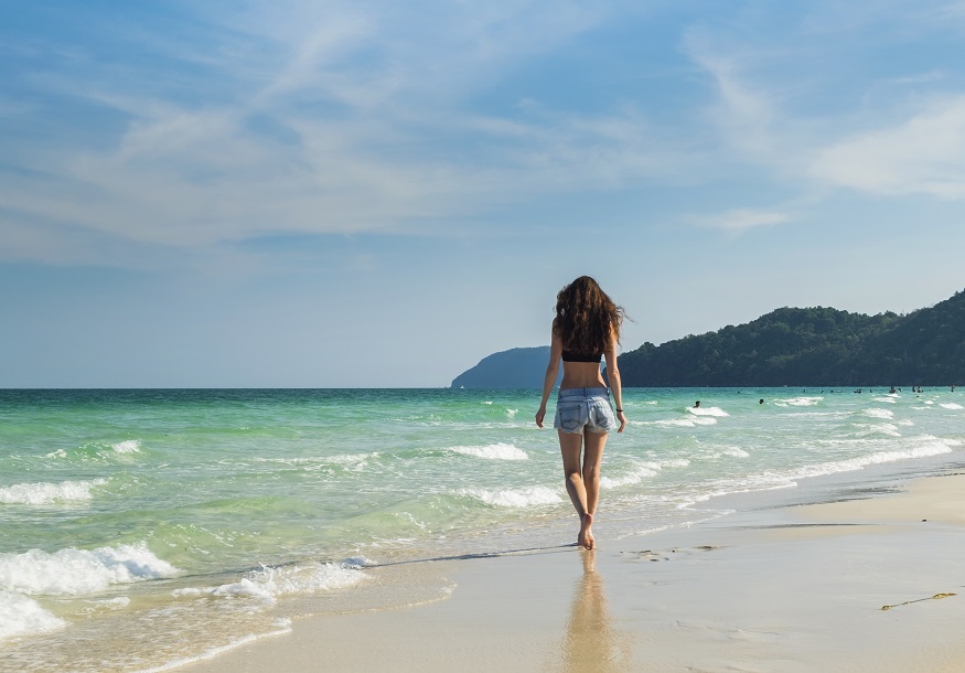 A tourist walking on the tropical beach