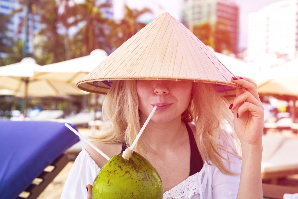 A tourist enjoy coconut on the beach of Vietnam